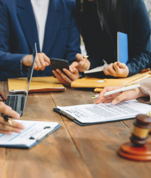 Business professionals and lawyers discussing contract papers during legal consultation meeting in Dubai